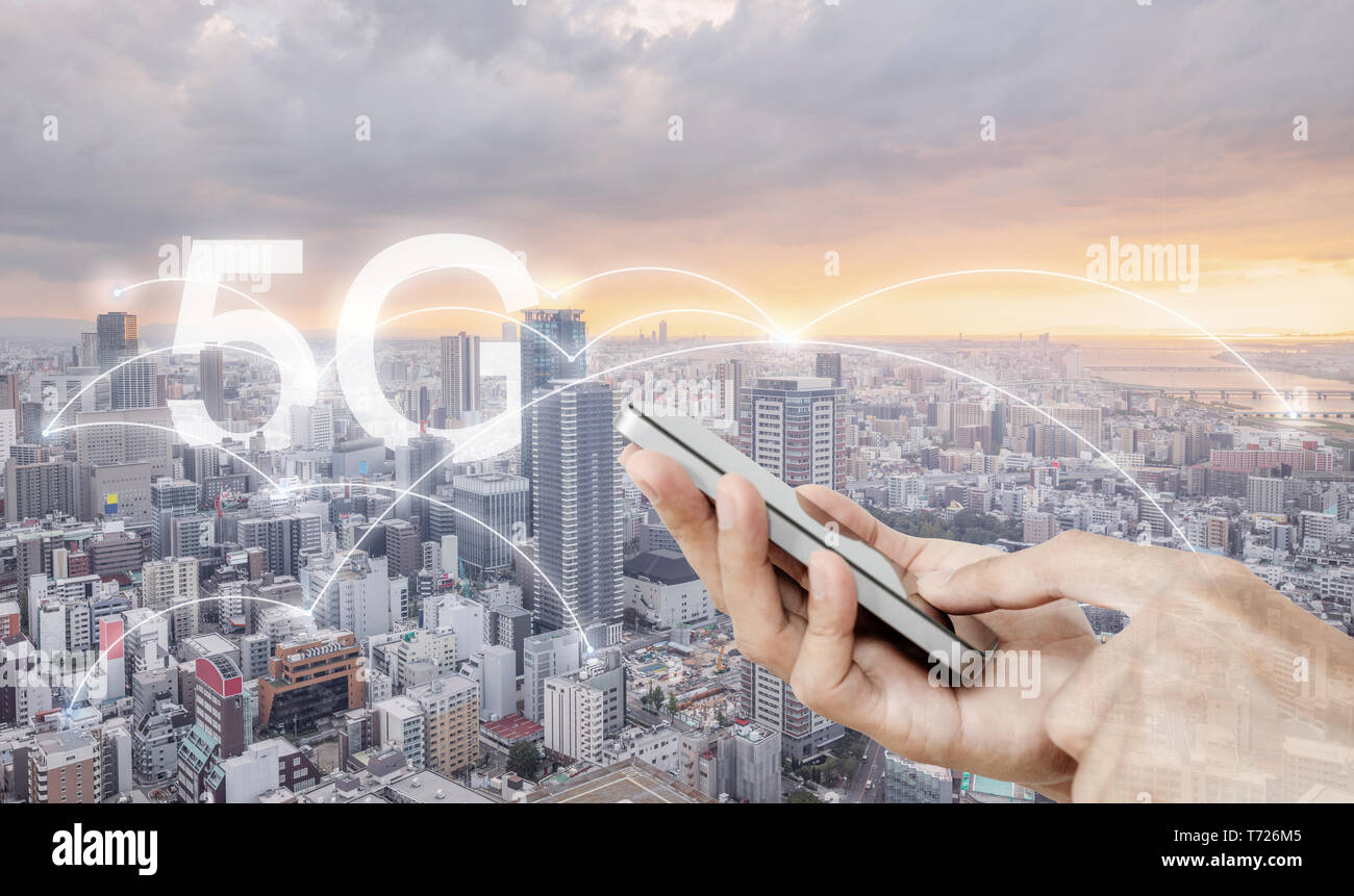 Mano utilizzando mobile smart phone, e la connessione di rete wireless della tecnologia nella città, con 5g internet segno di networking Foto Stock