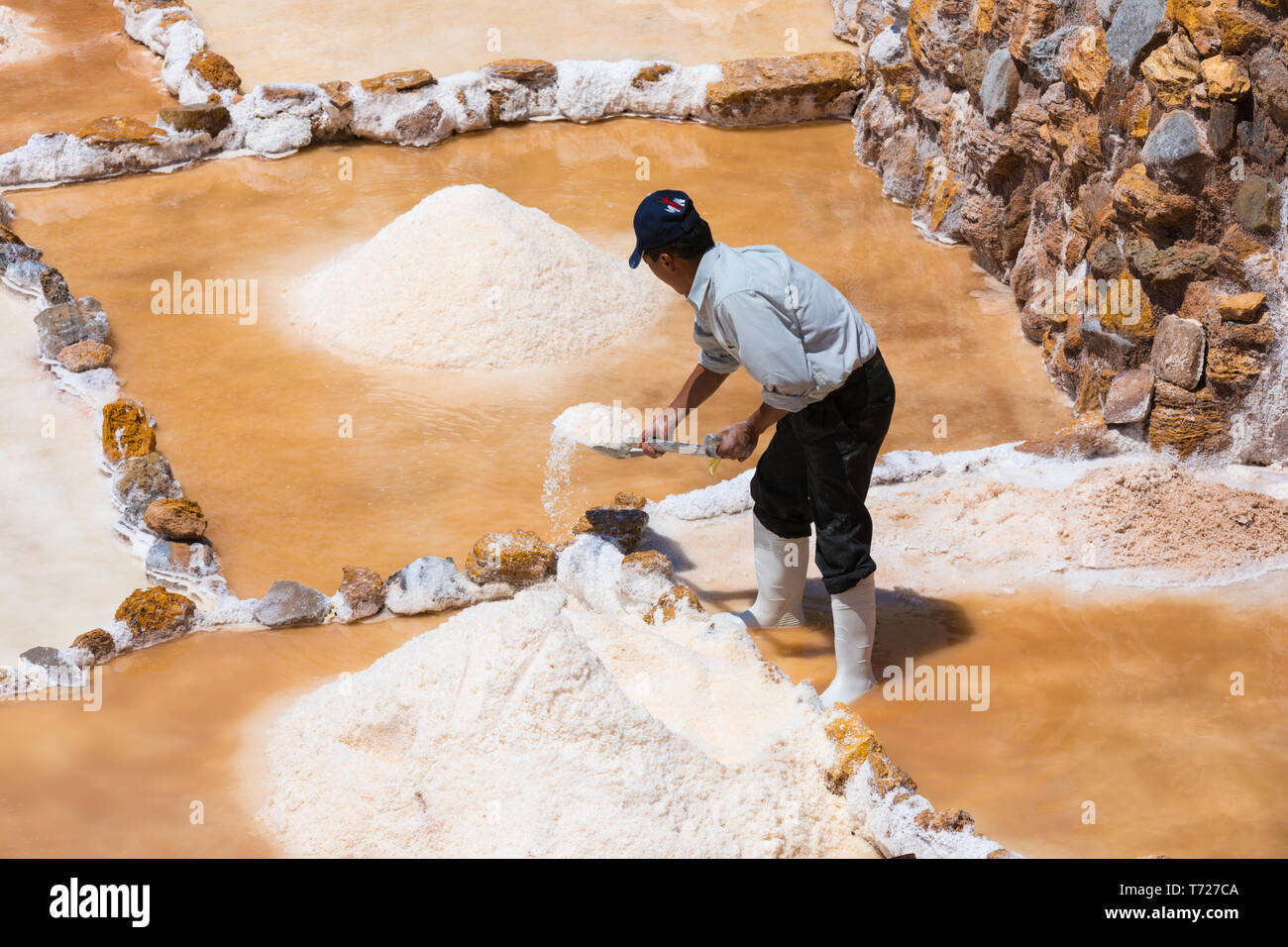 Lavoratore sale si sposta in un altro bacino terrazzati Moray Perù Foto Stock