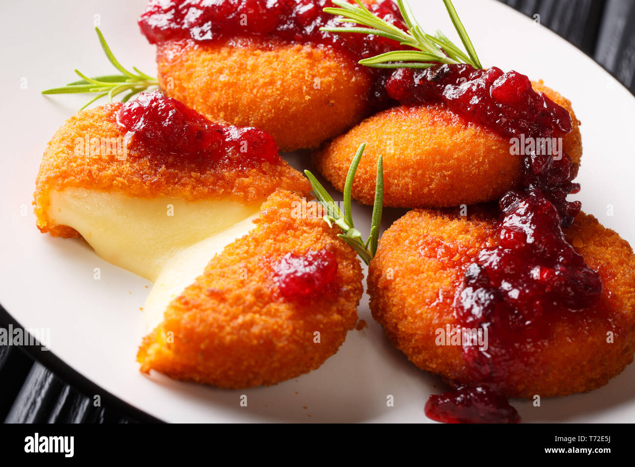 Cotta camembert fritto con salsa di mirtilli close-up su una piastra sul tavolo orizzontale. Foto Stock