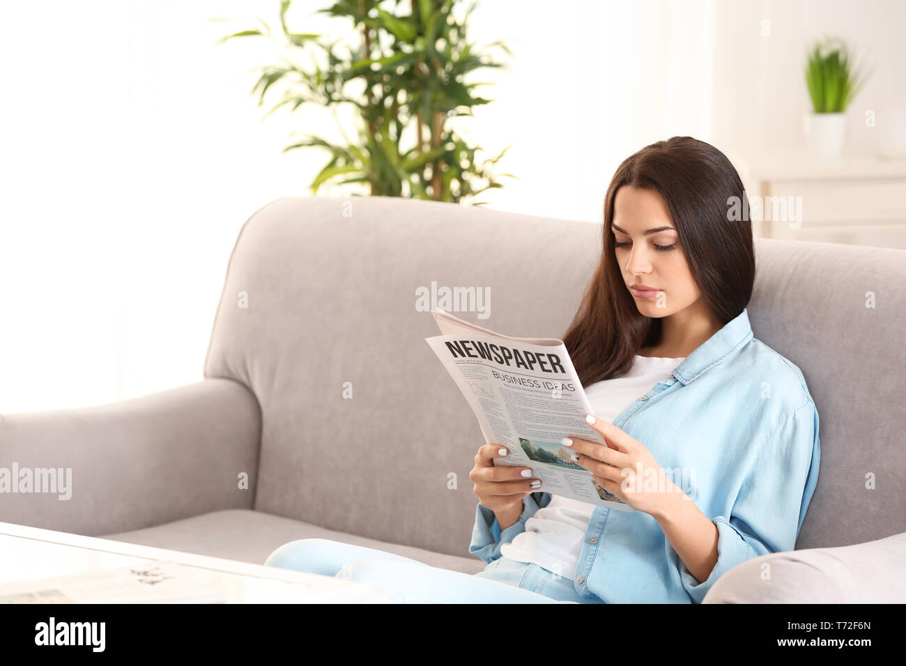 Giovane donna quotidiano di lettura in ambienti interni Foto Stock