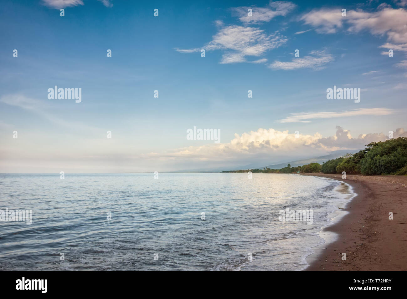 Una sabbia scura Beach a nord di Bali Indonesia Foto Stock