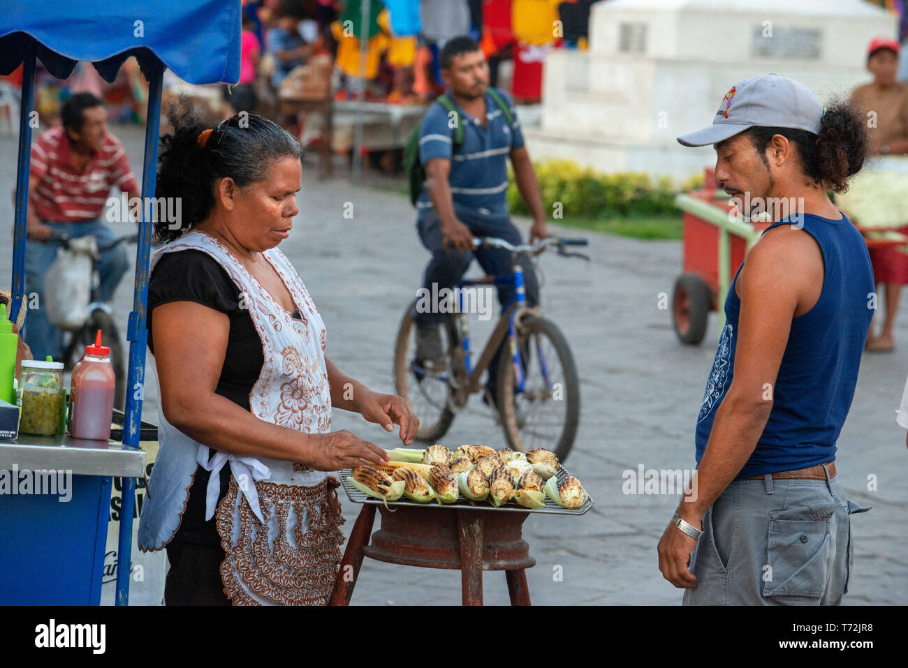 Donna locale di vendita di mais tostato cob stallo nella città coloniale di Granada Nicaragua america centrale. Pressione di stallo di strada cibo venditore nel Parque Central ho Foto Stock