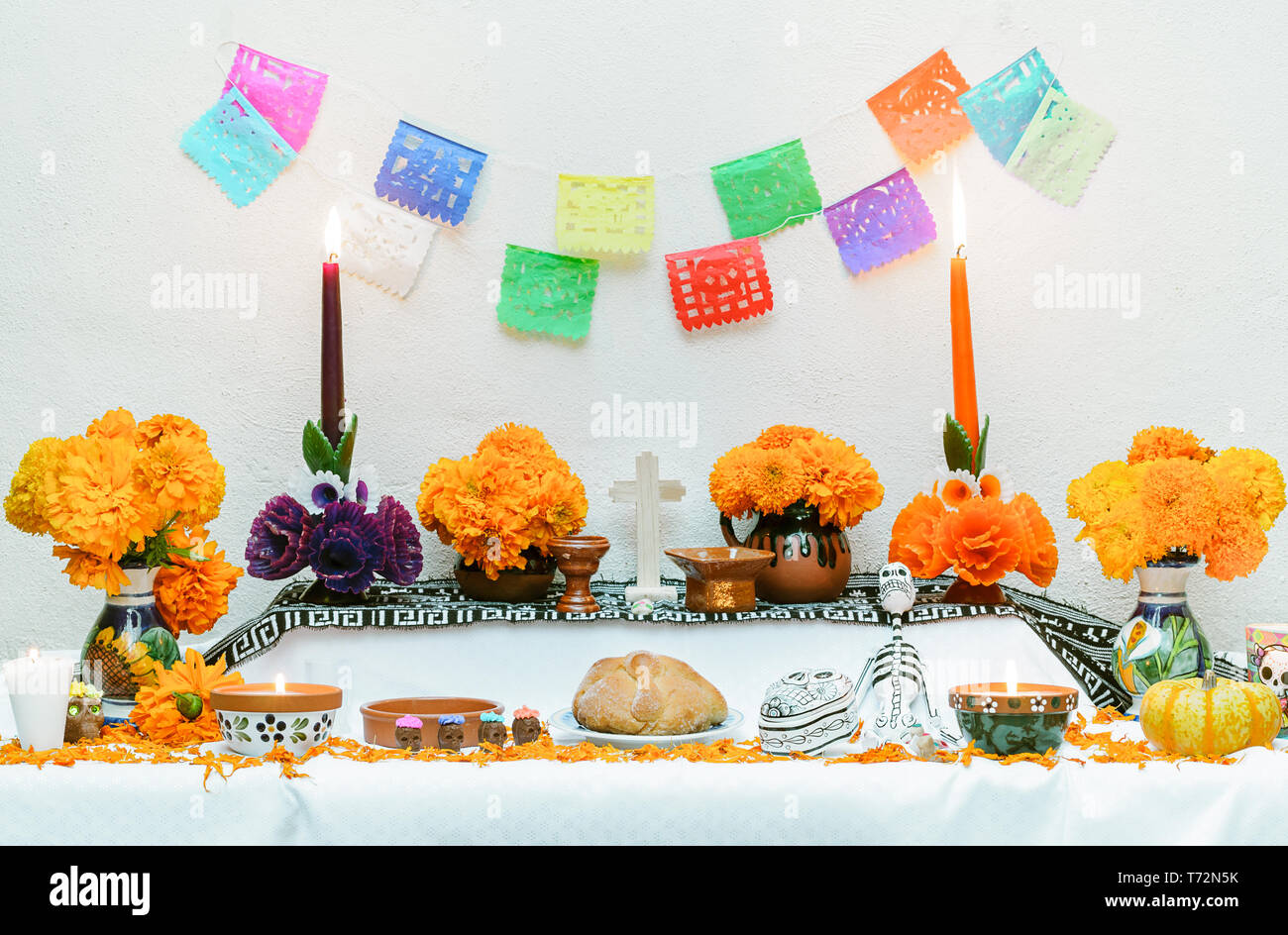 Tradizionale messicano il giorno dei morti altare con pan de muerto e candele su sfondo bianco Foto Stock