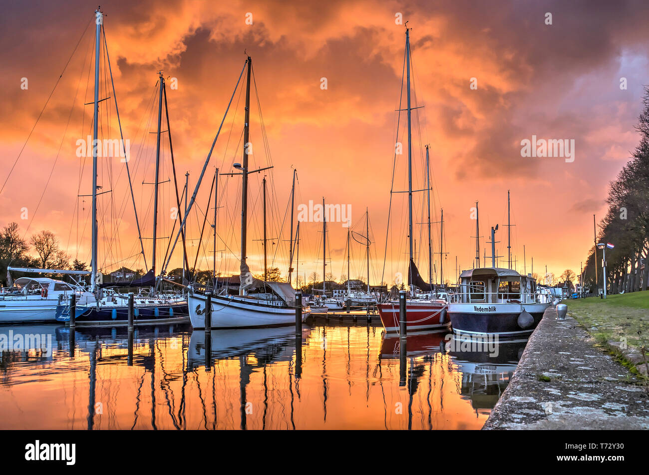 Medemblik, Paesi Bassi, ottobre 21, 2017: spettacolare cielo rosso su Westerhaven marina come il sole che illumina una massiccia nube di tuono Foto Stock