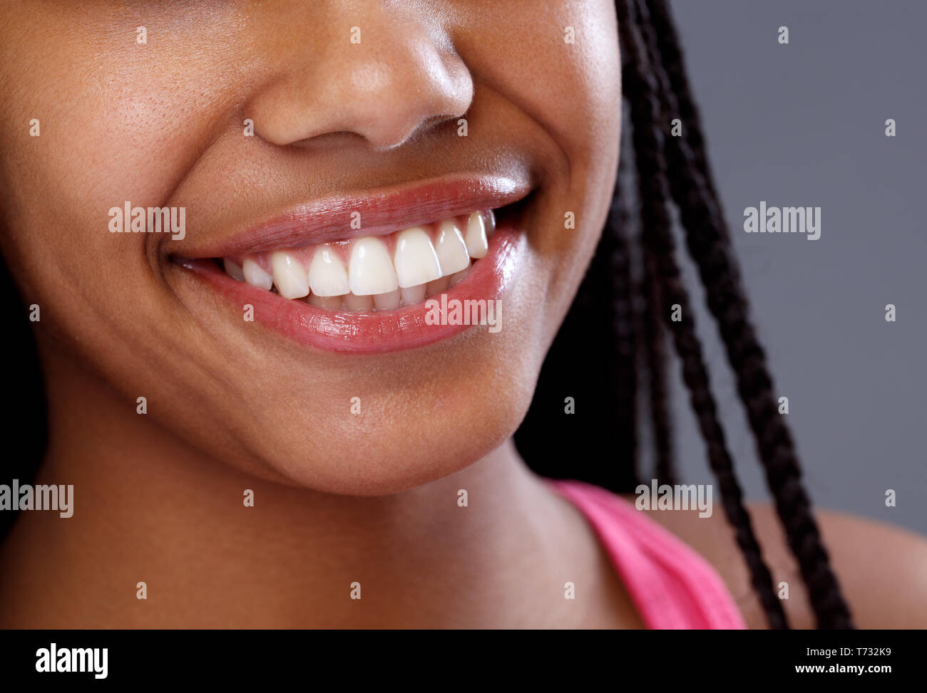 Close up di bianco lucido su denti sorridente donna africana Foto Stock