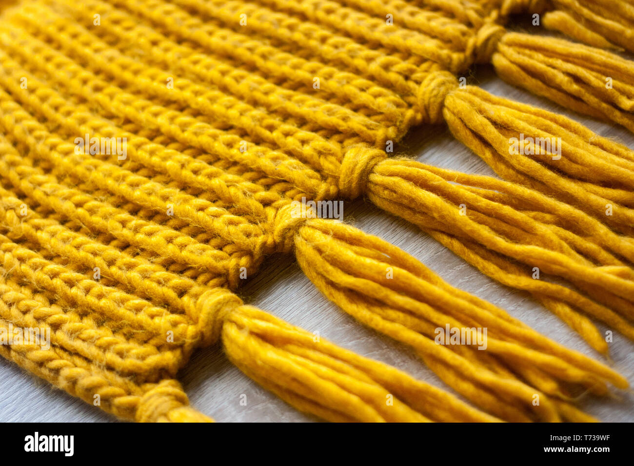 Maglia di lana foulard giallo sulla texture di sfondo di legno Foto Stock