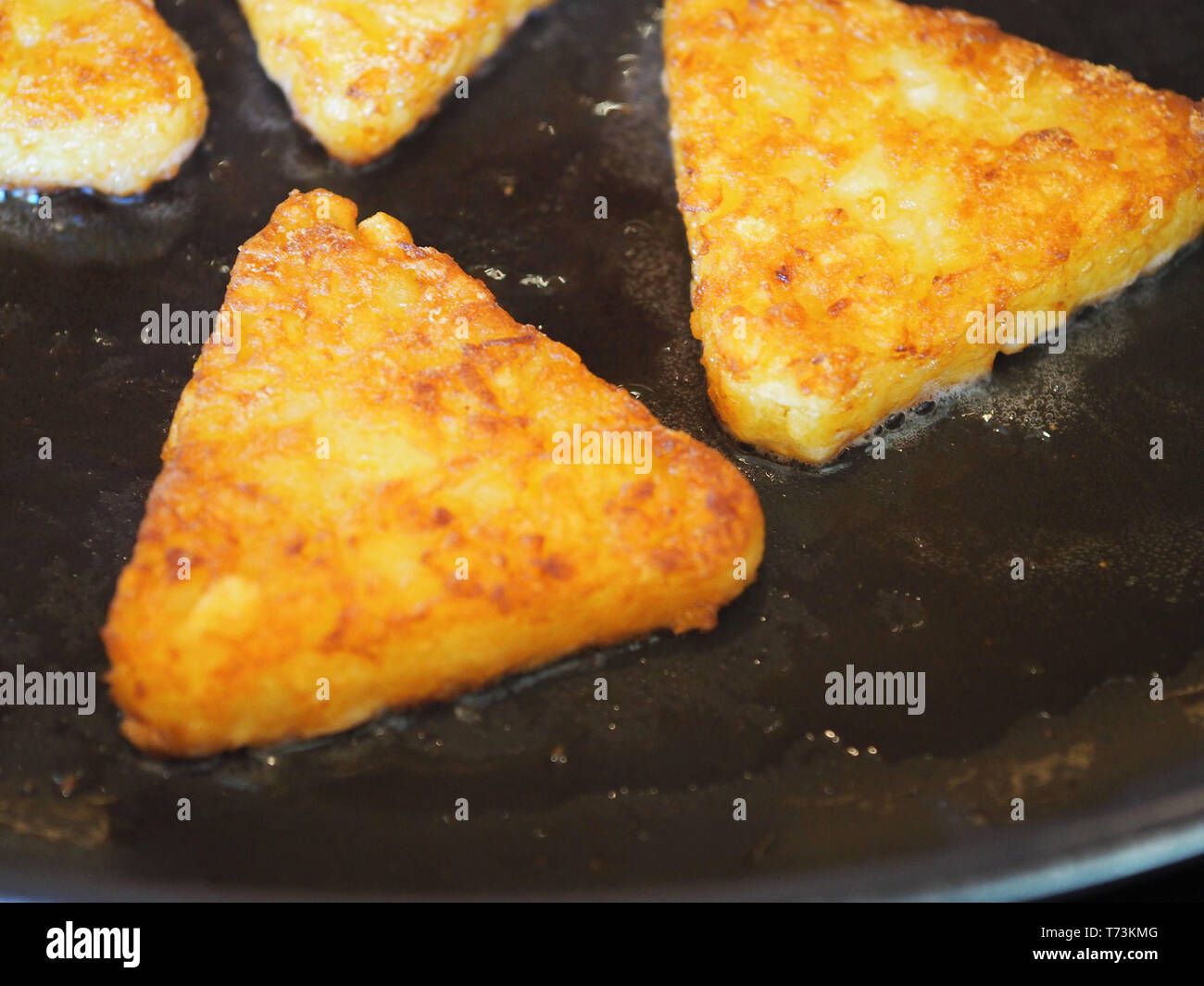 Triangolare angoli roesti fritti in padella oscuramente Foto stock - Alamy