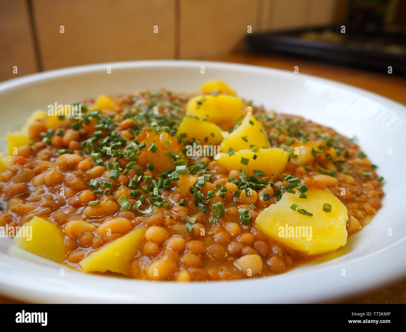 Delizioso piatto di lenticchie con patate e erba cipollina fresca Foto Stock