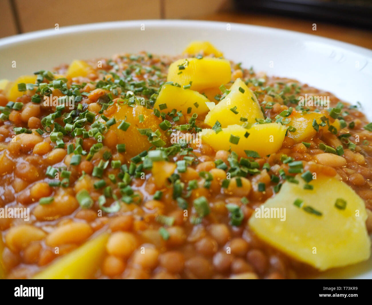 Delizioso piatto di lenticchie con patate e erba cipollina fresca Foto Stock