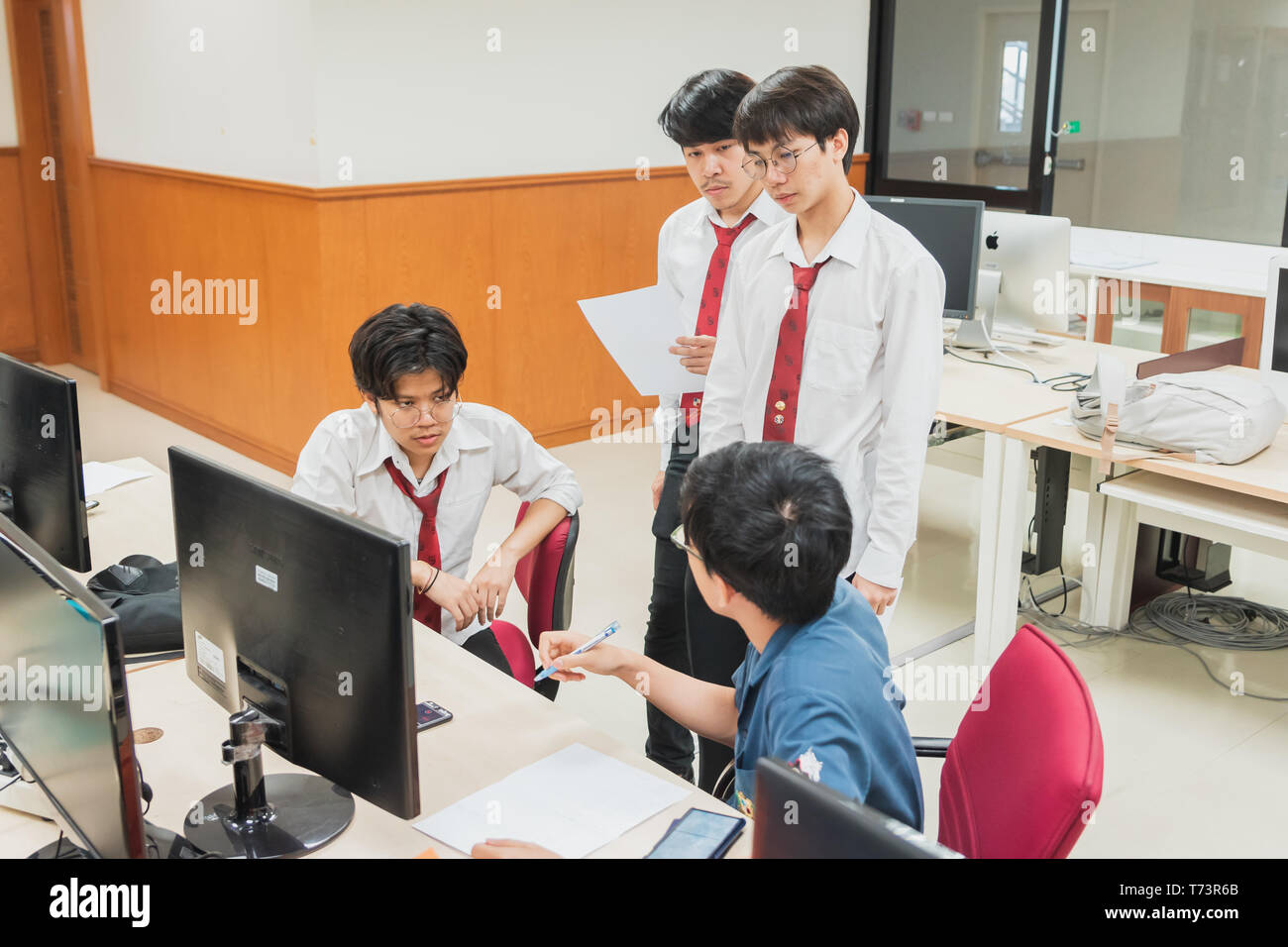 Gruppo di Thai gli Studenti Universitari per discutere sui loro computer finale del progetto di ingegneria in una università di laboratorio con computer Foto Stock