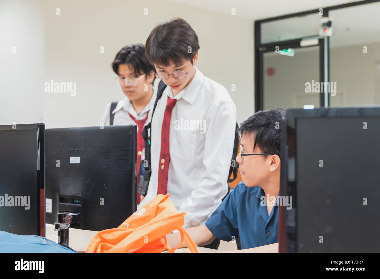 Gruppo di Thai gli Studenti Universitari per discutere sui loro computer finale del progetto di ingegneria in una università di laboratorio con computer Foto Stock