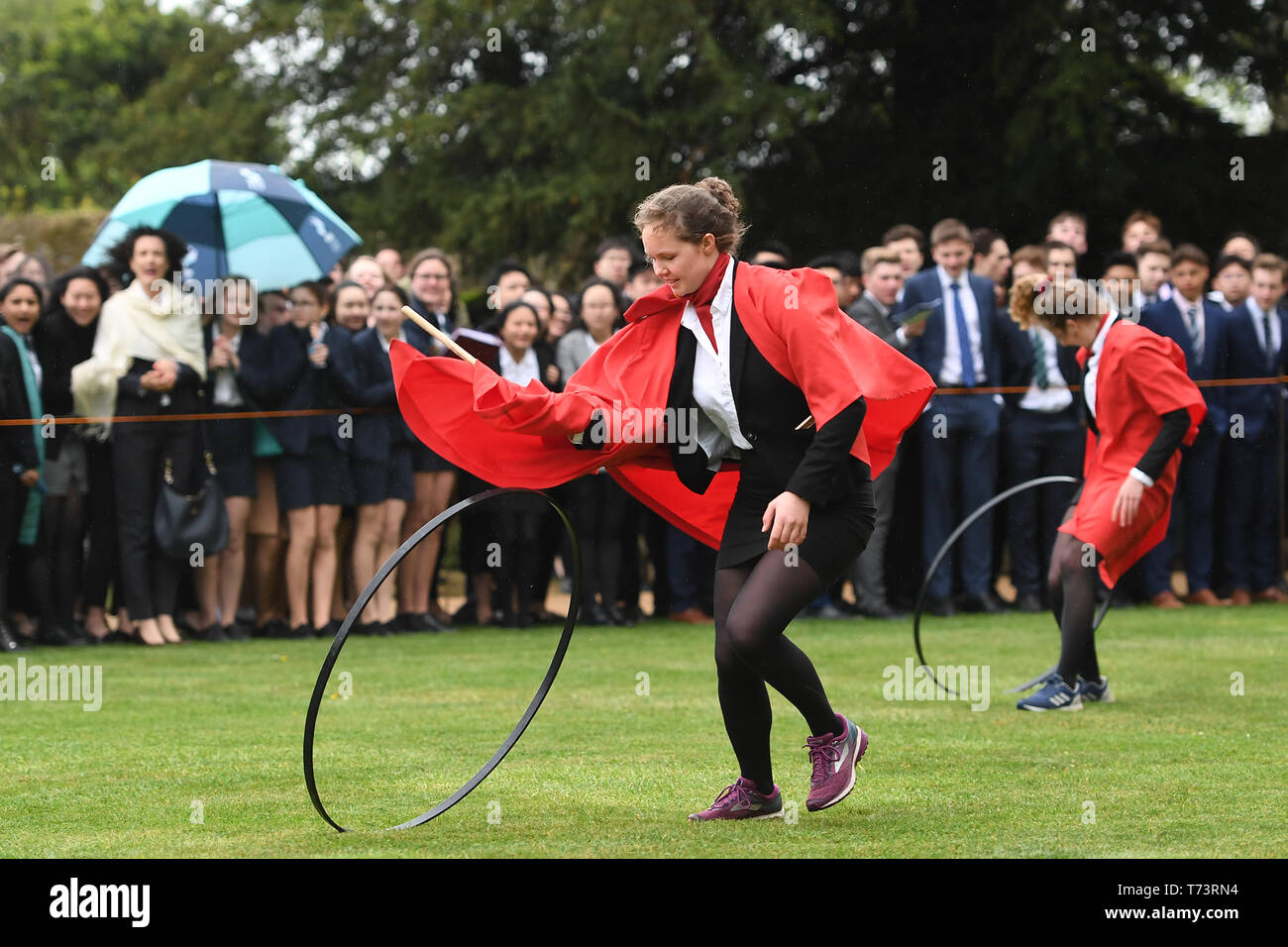 Gli studenti prendono parte all'annuale King's Ely Hoop Trundle sul prato Est a Ely Cathedral, per contrassegnare la rifondazione della scuola da parte di Re Enrico VIII nel 1541. Il corso è a 75 yard dash per un post e posteriore mentre bowling il cerchio con un bastone di legno. Foto Stock