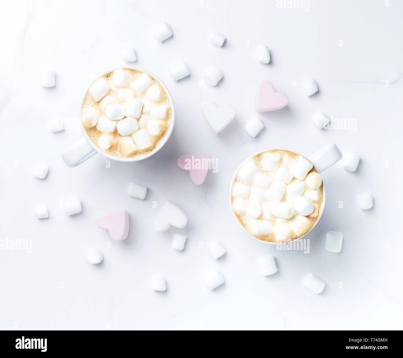 Romantico accogliente da scrivania con due tazze di caffè con marshmallows sulla tavola di marmo. Vista dall'alto. Foto Stock