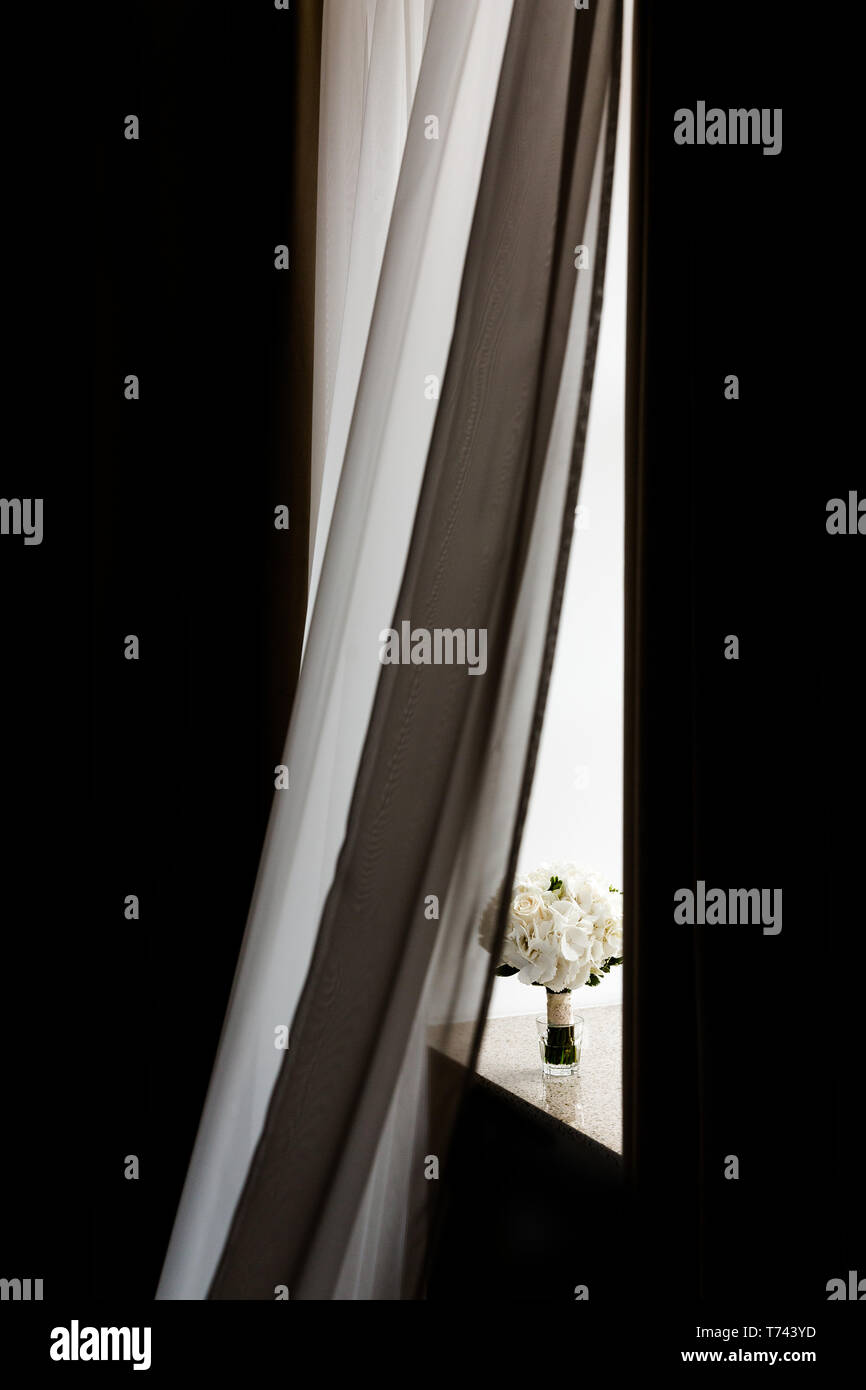 Bouquet nuziale sul davanzale dietro la tenda Foto Stock