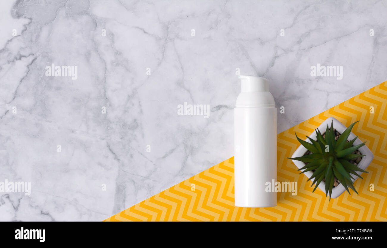 Bottiglia di cosmetici con impianto su sfondo marmo. Lay piatto. Bio prodotto biologico concetto di prodotto. Etichetta vuota per il branding mockup. Foto Stock