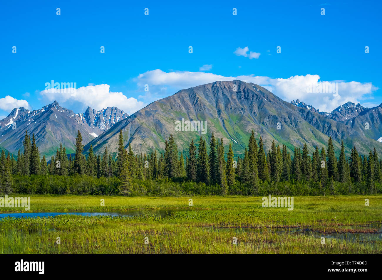 Nuvole rolling attraverso picchi di montagna nella gamma Talkeetna nel centro-sud della Alaska su una soleggiata giornata estiva; Alaska, Stati Uniti d'America Foto Stock