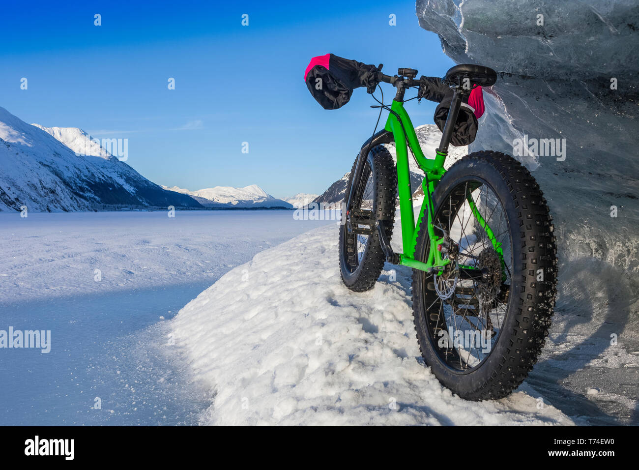 Green Fatbike 907 Whiteout bike in appoggio sul gigantesco iceberg in inverno sul lago di Portage, Chugach National Forest; Portage, Alaska, Stati Uniti d'America Foto Stock