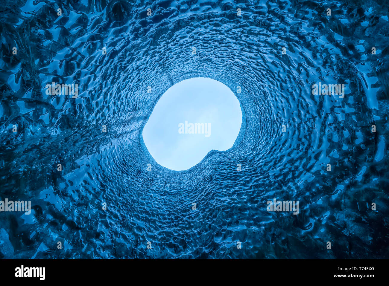 Guardando dritto fino un foro nel tetto della caverna di ghiaccio; Islanda Foto Stock
