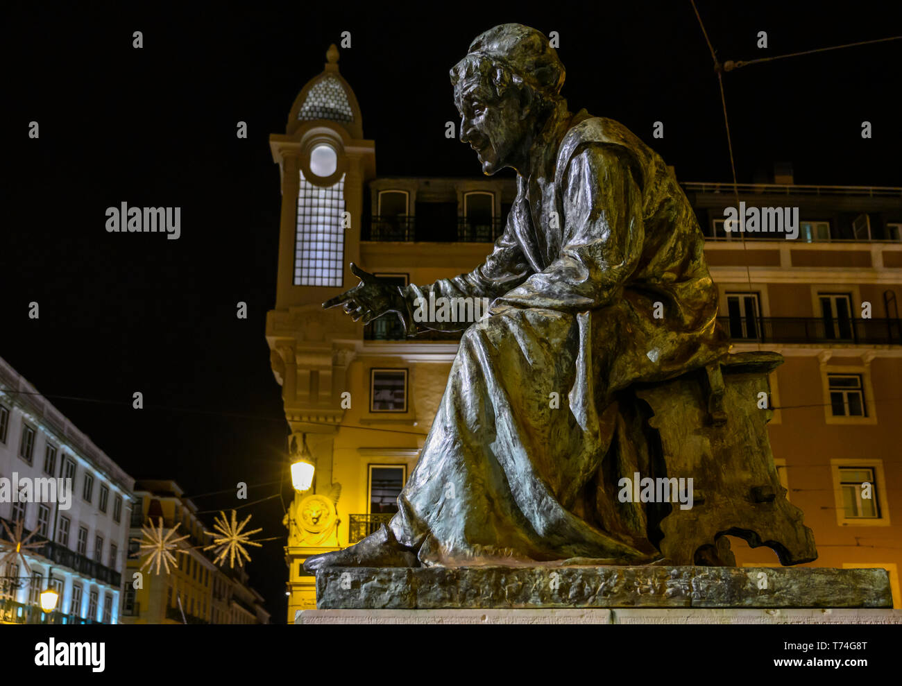 Statua di un uomo seduto in una piazza cittadina di notte; Lisbona, regione Lisboa, Portogallo Foto Stock