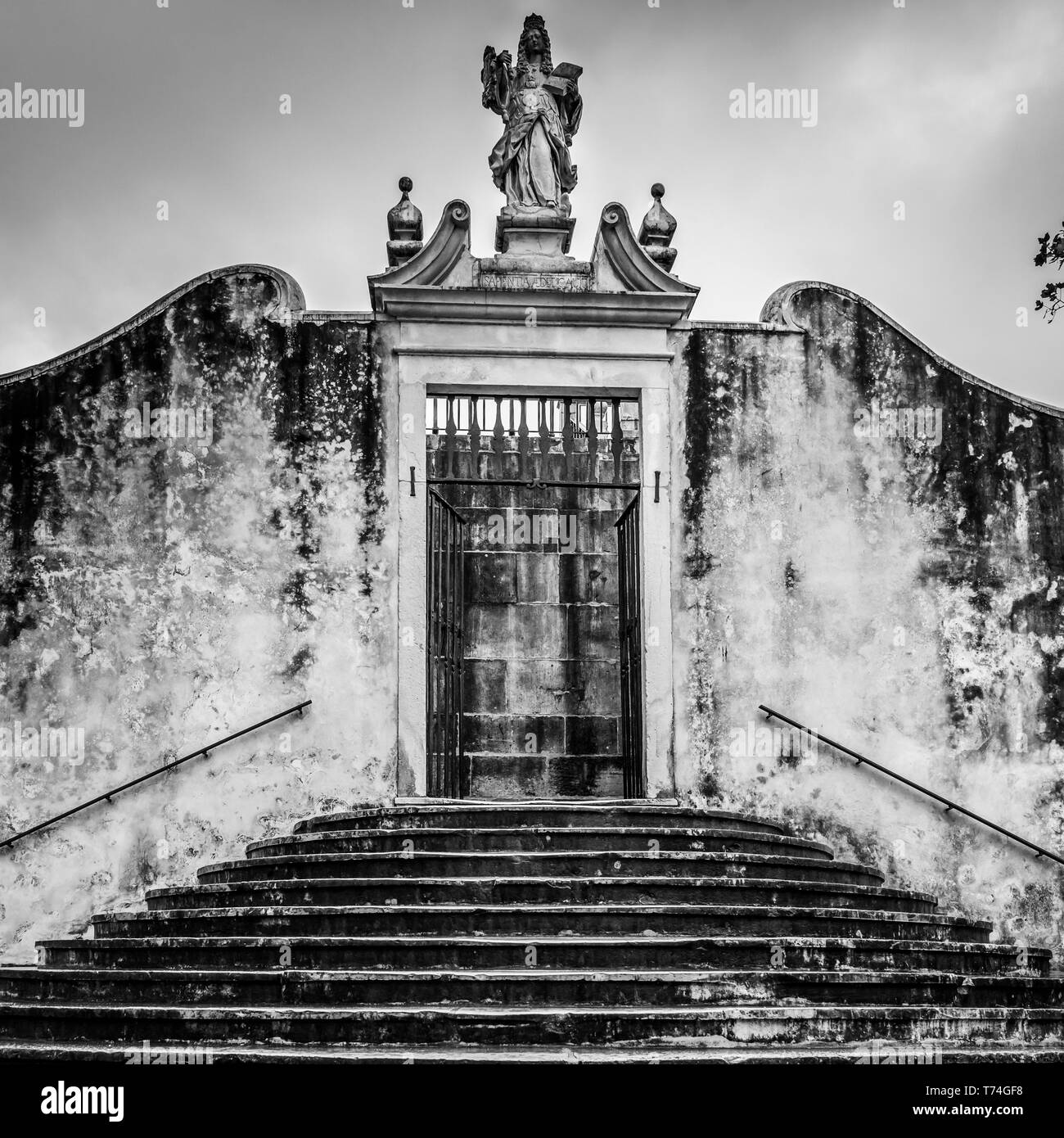 Weathered esterno dell'edificio con statua sopra la porta; Coimbra, Distretto di Coimbra, Portogallo Foto Stock