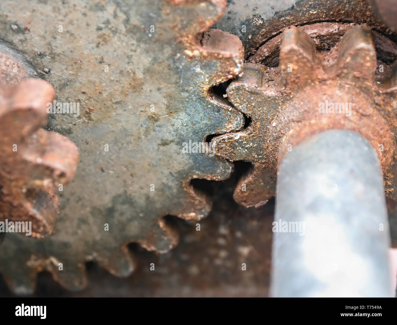 Un grande e un piccolo ingranaggio in ogni altro e vecchie e arrugginite in close-up, i denti di una terza ruota dentata può essere visto sulla sinistra. Foto Stock