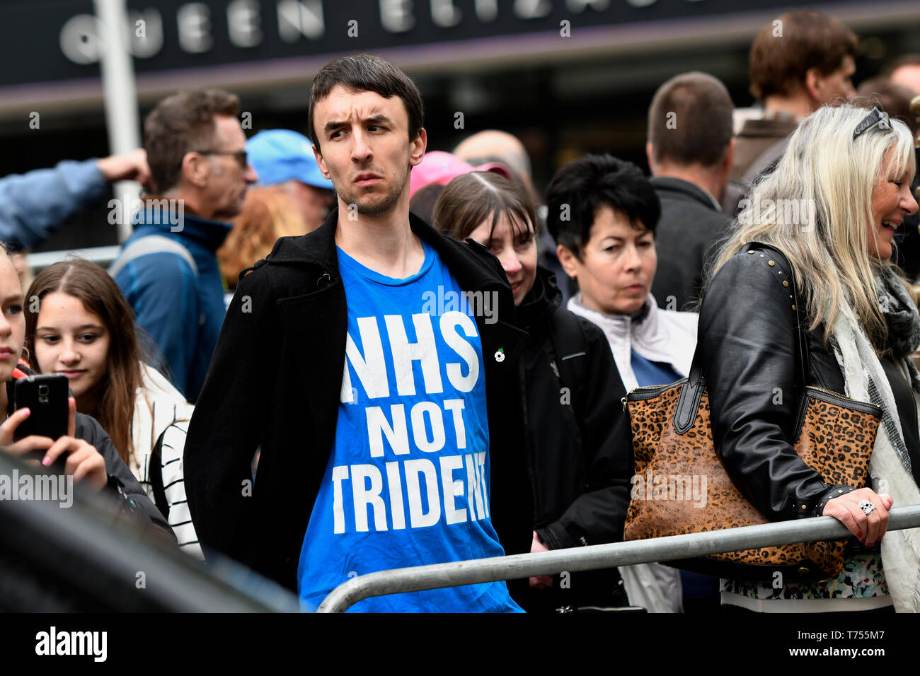 Attivista visto indossare una t-shirt che dice, NHS non trident, durante la protesta. Gli attivisti anti-nucleari si sono riuniti di fronte all'Abbazia di Westminster a Londra per protestare contro un servizio di ringraziamento organizzata dalla Royal Navy per contrassegnare 50 anni di Gran Bretagna il sommergibile a base di armi nucleari. Gli attivisti anti-nucleari eseguito un "die-in" fuori Abbazia di Westminster che rappresentano le vittime di una guerra nucleare. Foto Stock