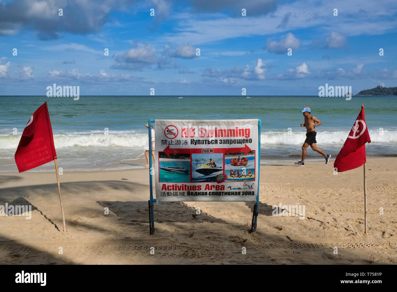 All'inizio della stagione delle piogge, spia rossa di bandiere e di un segnale di avvertimento a Patong Beach, Phuket, Thailandia, raccomanda ai visitatori di non nuotare Foto Stock