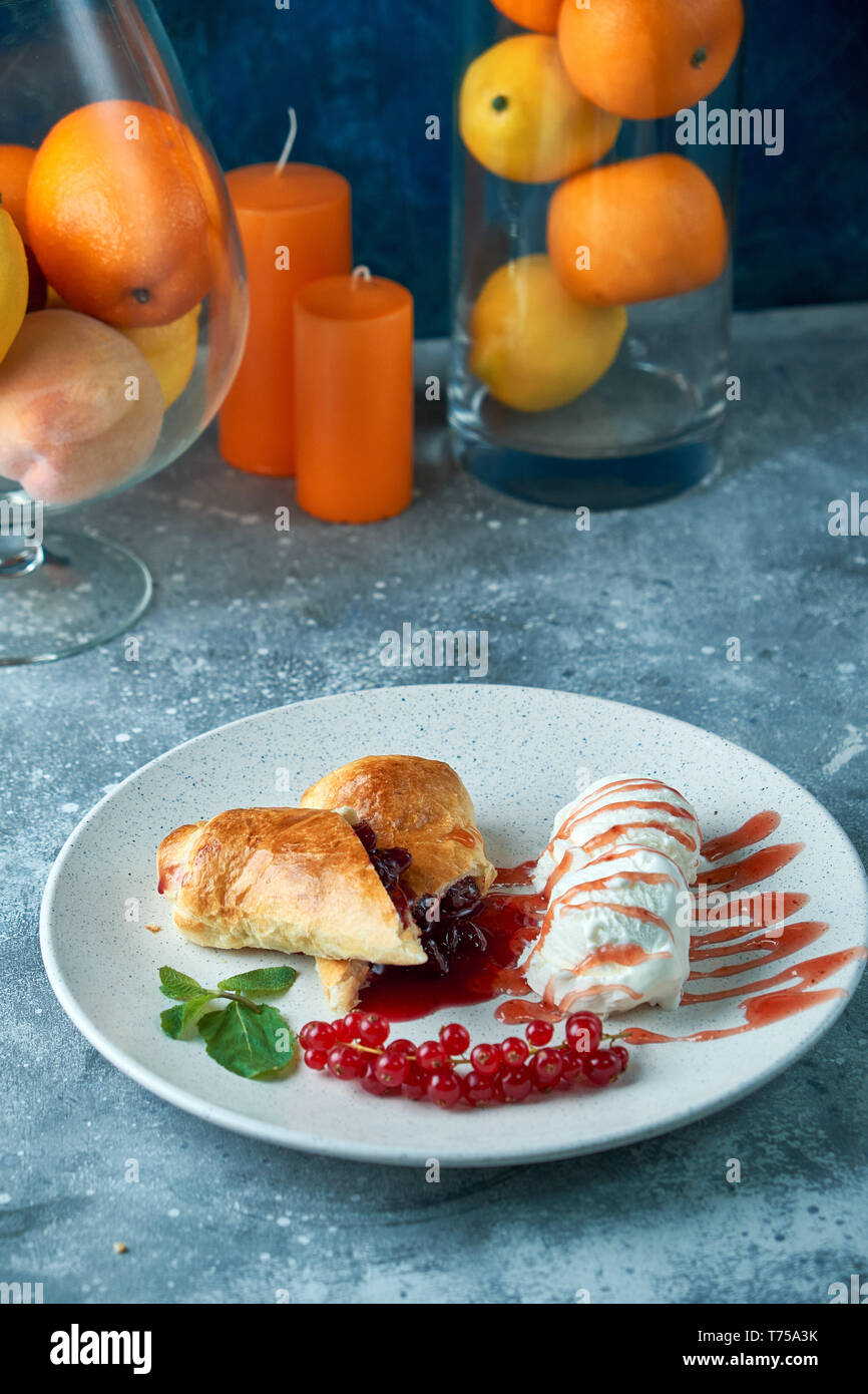 Affettato in casa berry strudel serviti con carni rosse bacche Ribes e zucchero in polvere su un vecchio sfondo su una piastra con gelato pic Foto Stock