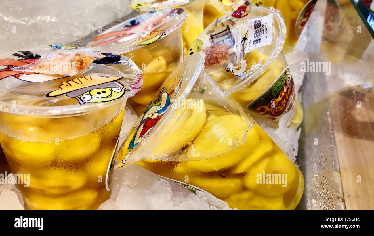 Saigon/Vietnam: 1 Apr 2019: Delicious gialla fette di mango con sale peperoncino piccante salsa di immersione vietnamita cibo di strada sul ripiano con cubetti di ghiaccio Foto Stock