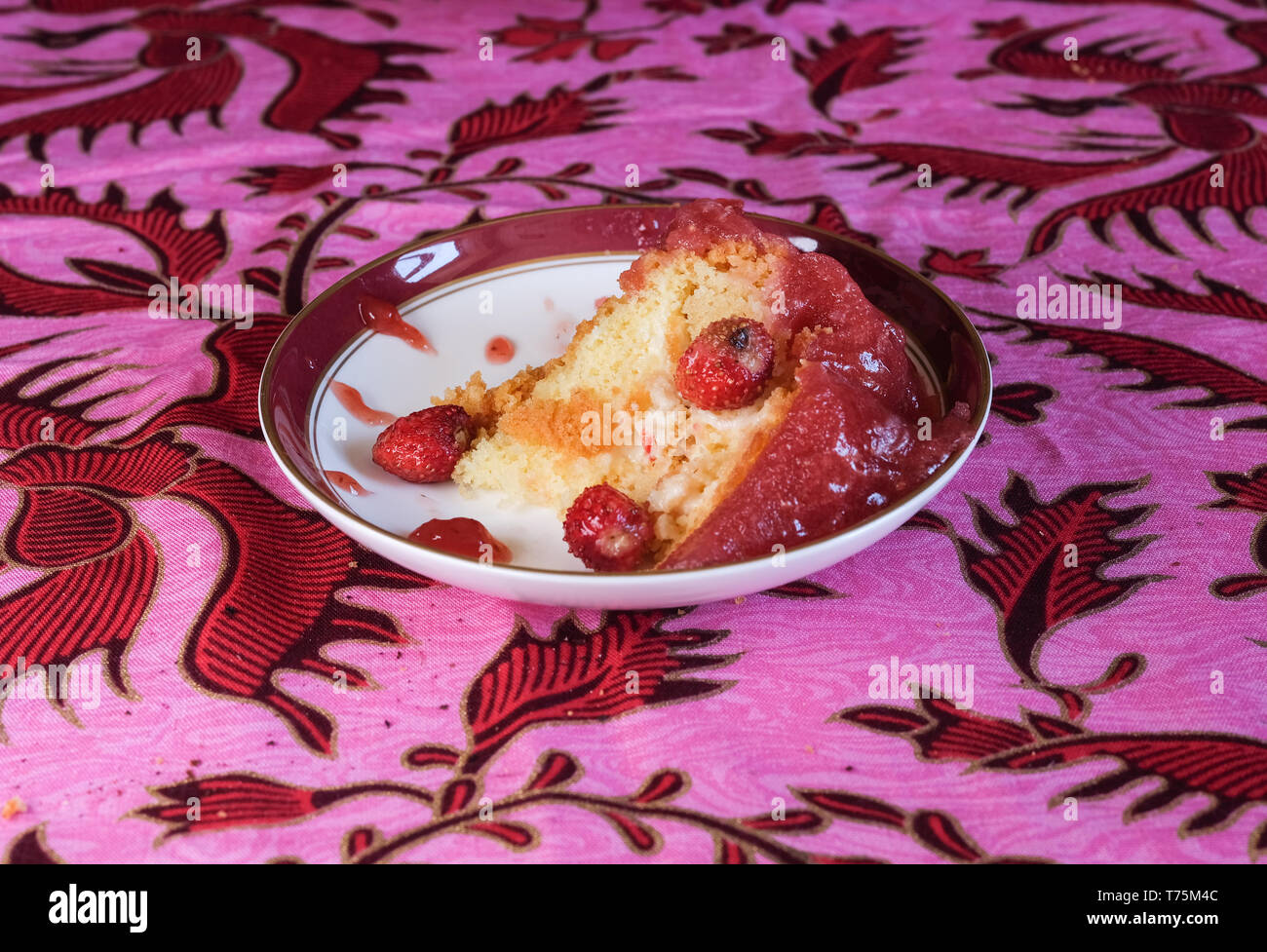 La fragola e la torta di panna su una tovaglia rosa backround Foto Stock