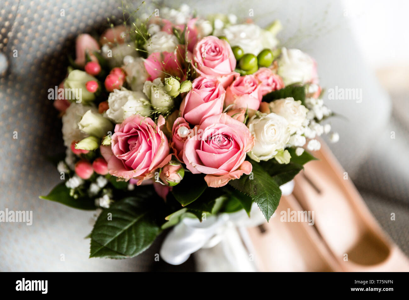 Bouquet di nozze del bianco e del rosa rose su uno sfondo sfocato della sposa le scarpe Foto Stock