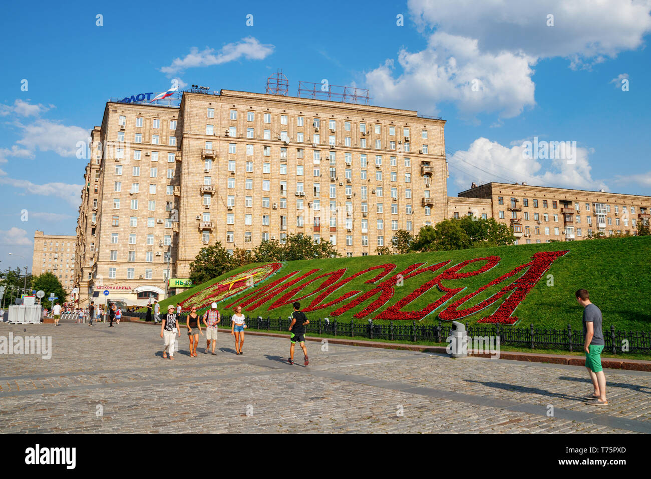 La Collina Poklonnaya, Kutuzovsky Prospekt con edifici residenziali e 'Mosca' scritto in rosso fiori su un bel pomeriggio di sole in estate. Mosca, Russia. Foto Stock