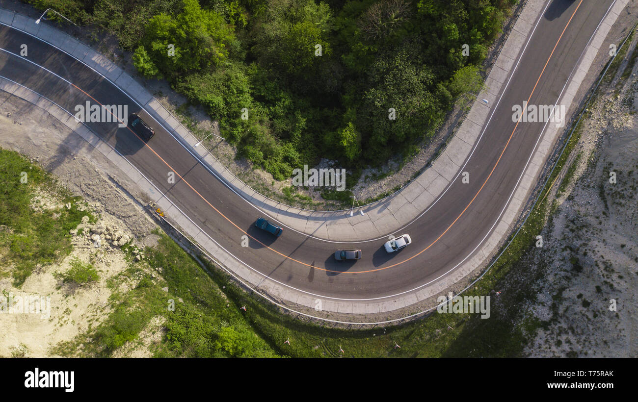 Direttamente sopra vista: di automobili sulla guida a zig zag tortuosa strada di montagna Foto Stock