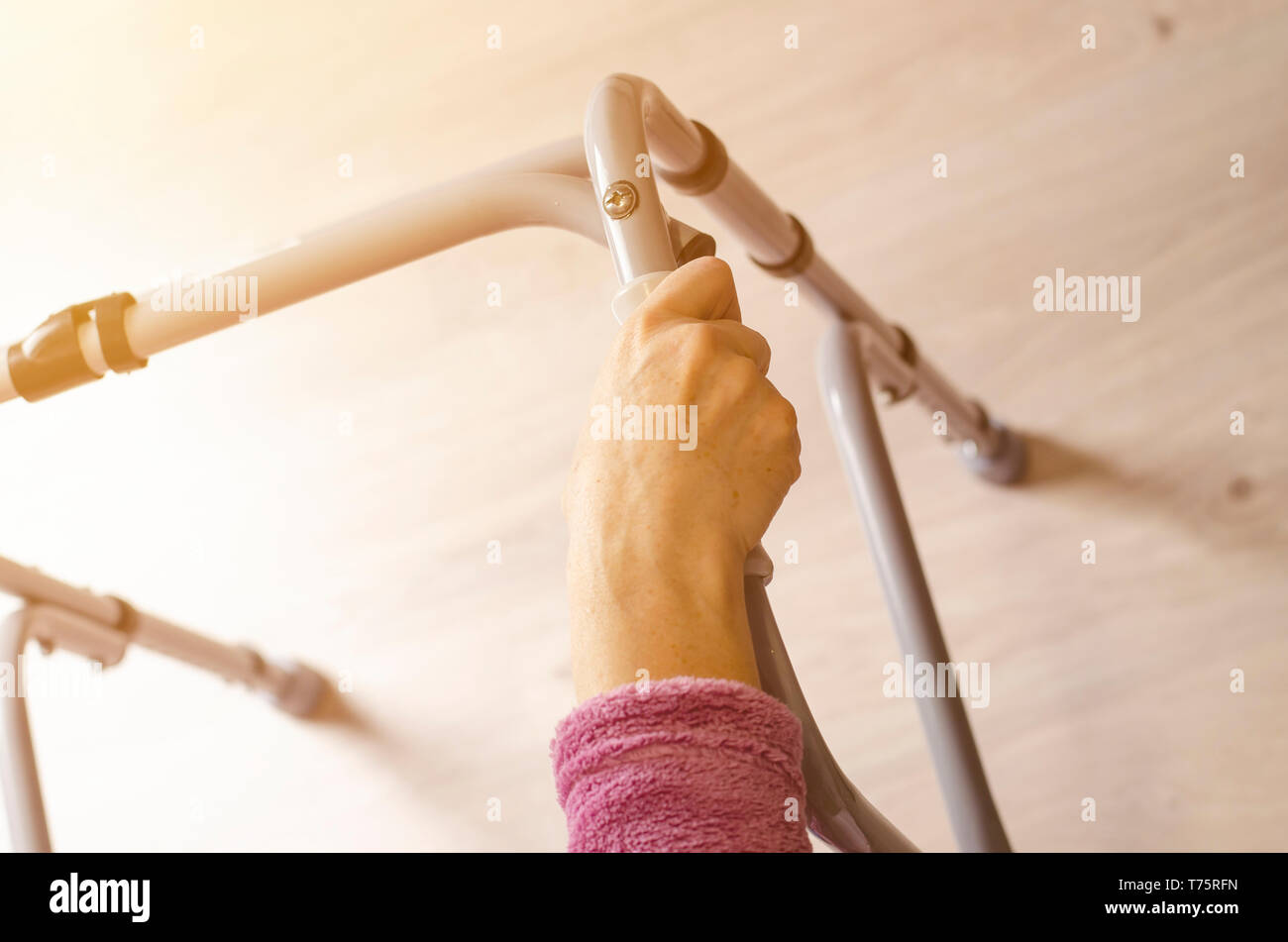 Le mani della donna anziana sulle maniglie di un deambulatore. Azioni di riabilitazione e di assistenza sanitaria concetto. Spazio di copia Foto Stock