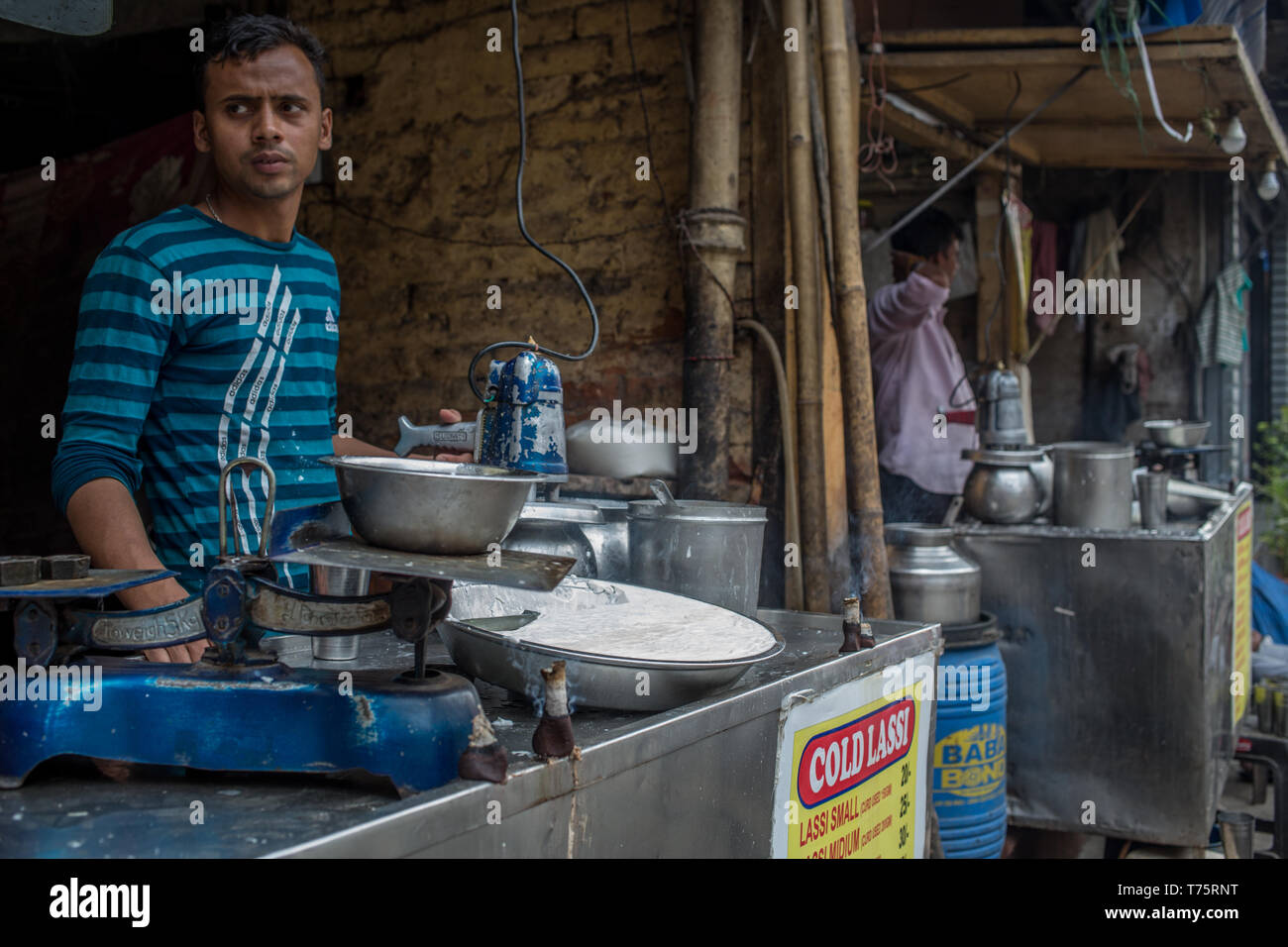 Un uomo vendere lassi, un tradizionale indiana yogurt da bere, nel centro cittadino di Nuova Delhi, India. Foto Stock