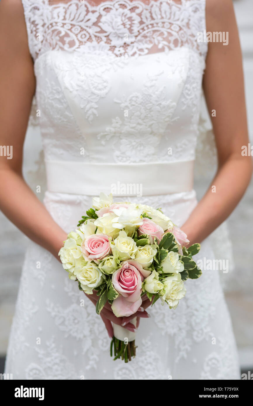 Irriconoscibile sposa tenendo un matrimonio raffinato bouquet di rose e  peonie con eusmoy bianco e tulipani Foto stock - Alamy