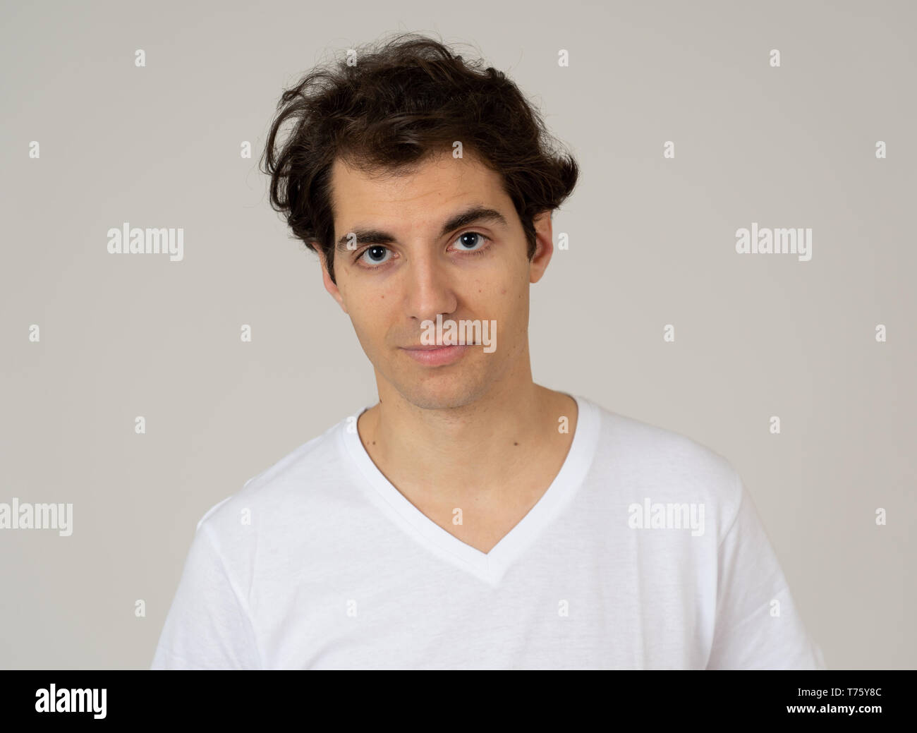 Close up headshot di giovani latino-uomo con naturale e faccia seria e divertente guardare. Isolato su sfondo neutro. In Persone, moda, lifestyle Beaut Foto Stock