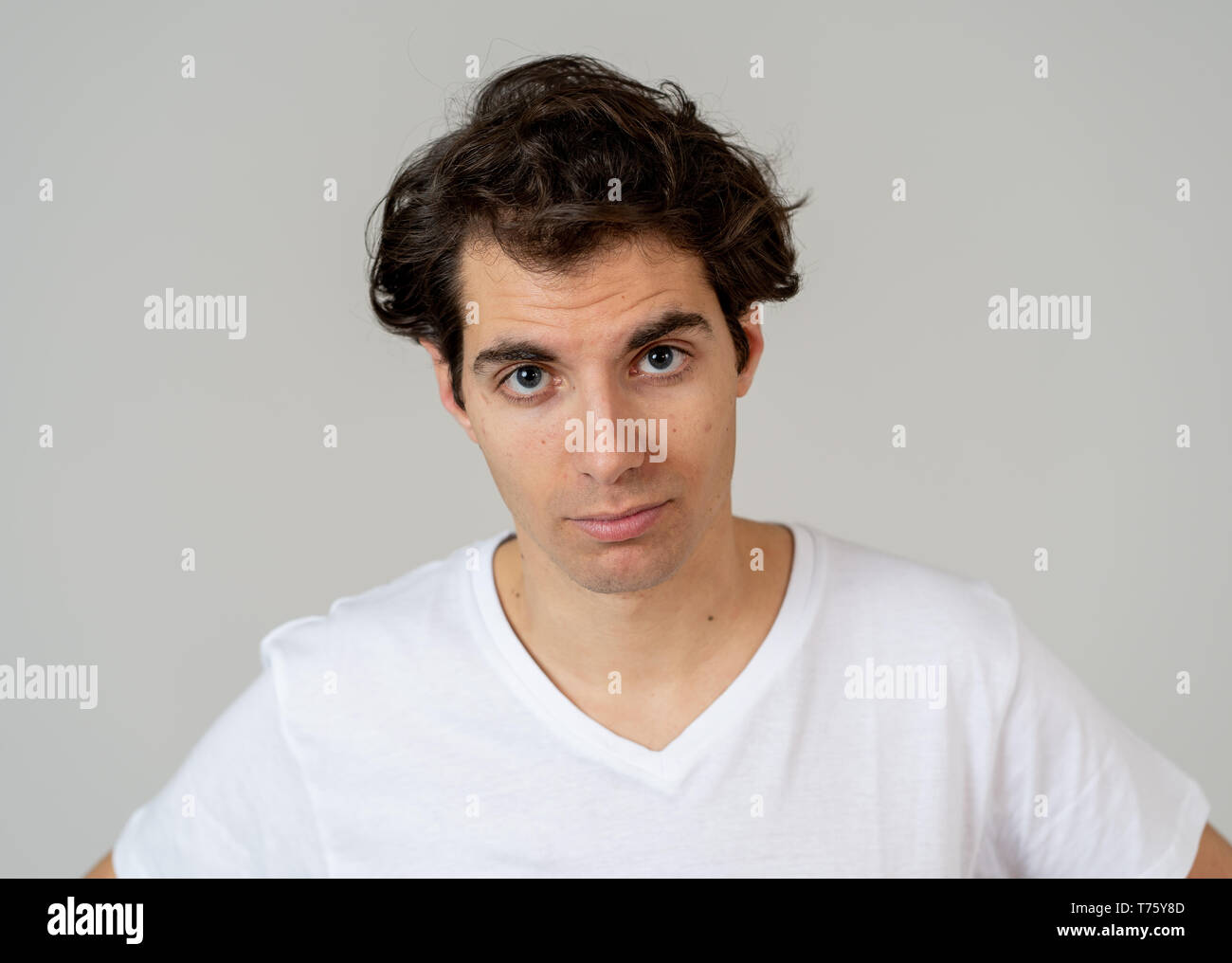 Close up headshot di giovani latino-uomo con naturale e faccia seria e divertente guardare. Isolato su sfondo neutro. In Persone, moda, lifestyle Beaut Foto Stock