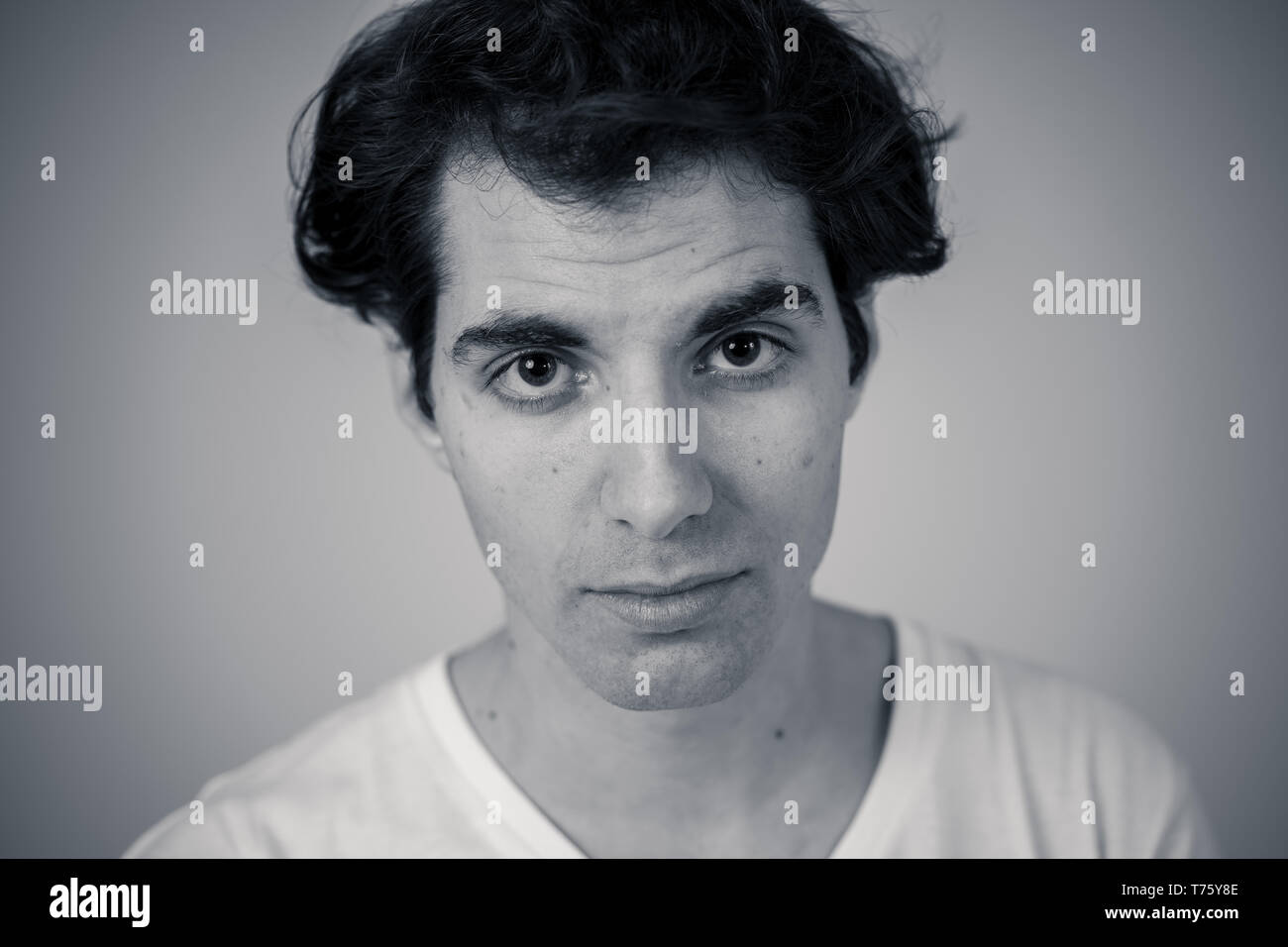 Close up headshot di giovani latino-uomo con naturale e faccia seria e divertente guardare. Isolato su sfondo neutro. In Persone, moda, lifestyle Beaut Foto Stock