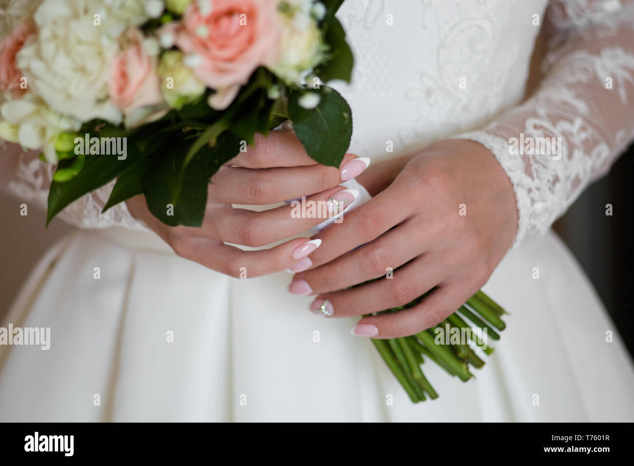 Wedding bouquet di rose rosa e bianco freesias nelle mani della sposa Foto Stock