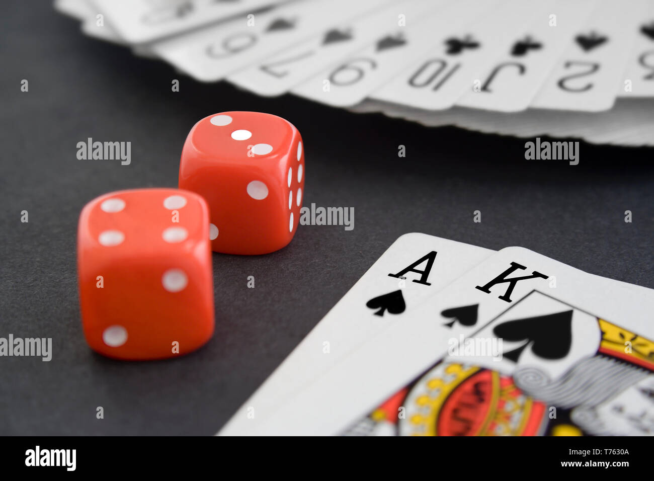 Carte da gioco e dadi sulla superficie nera Foto Stock