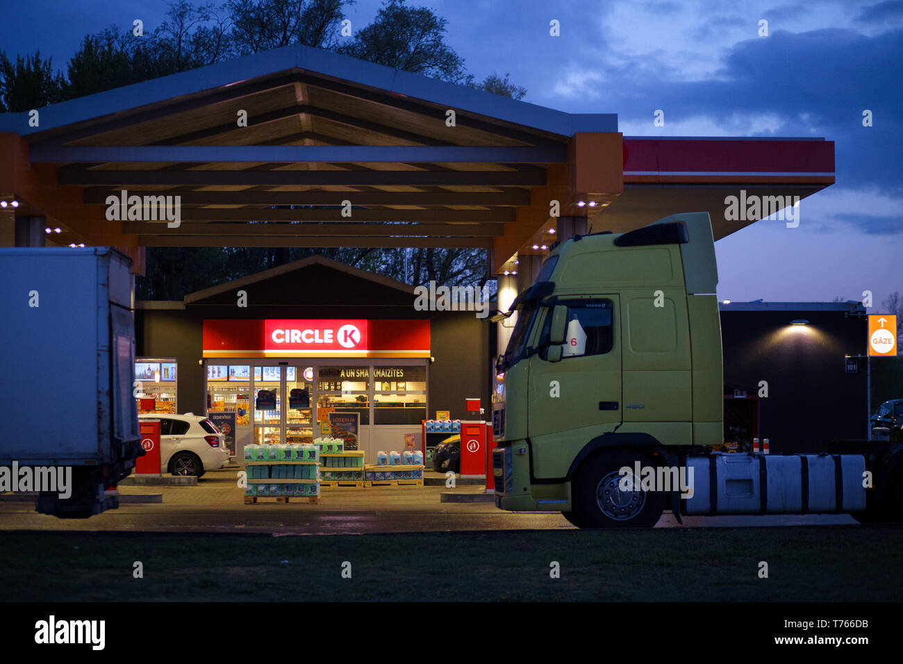 RIGA, LETTONIA - 3 MAGGIO 2019: Stazione di rifornimento Circle K DUS sulla strada Krasta vista frontale con camion in primo piano durante un tramonto vivace Foto Stock