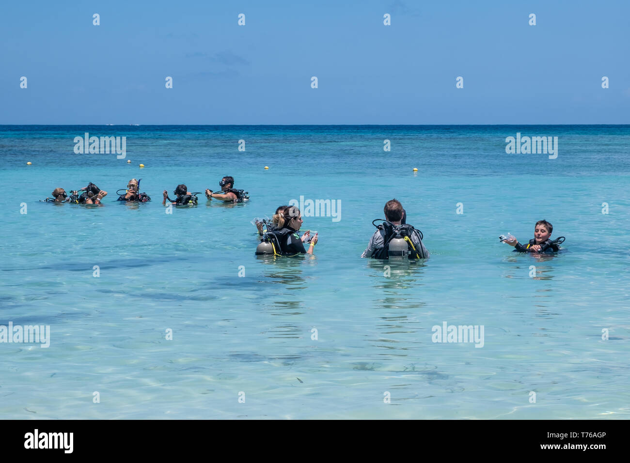 I subacquei in piena attrezzatura subacquea a prepararsi per un tuffo fuori Riva del West Bay Roatan Honduras. Foto Stock