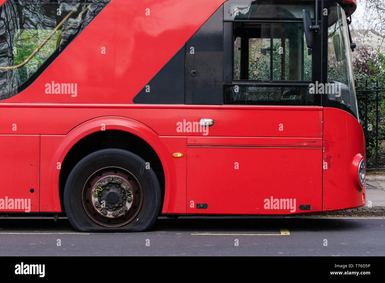 Il pneumatico sgonfio su un bus rosso a due piani a Londra. Foto Stock
