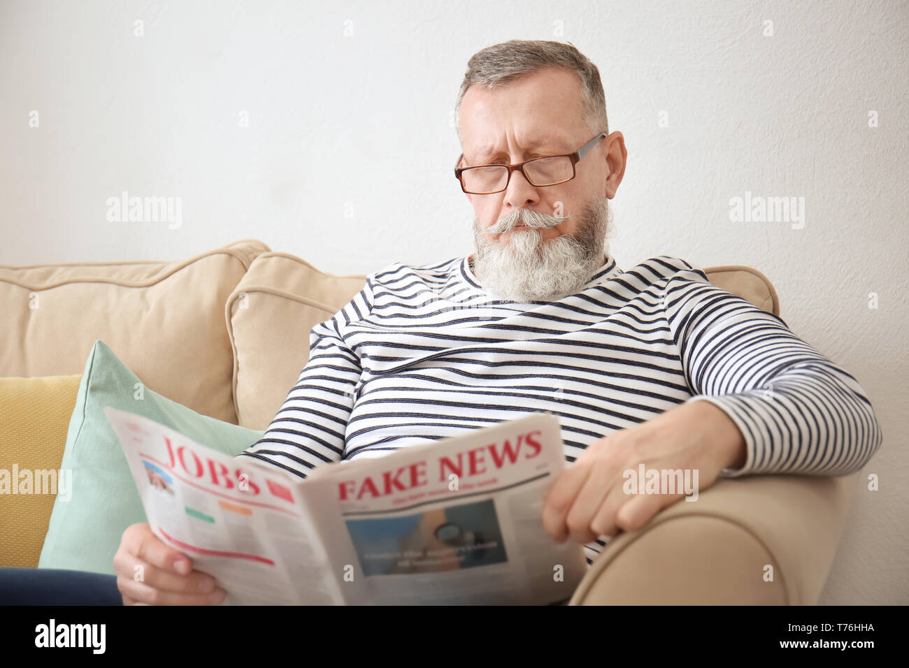 Senior uomo quotidiano di lettura a casa Foto Stock