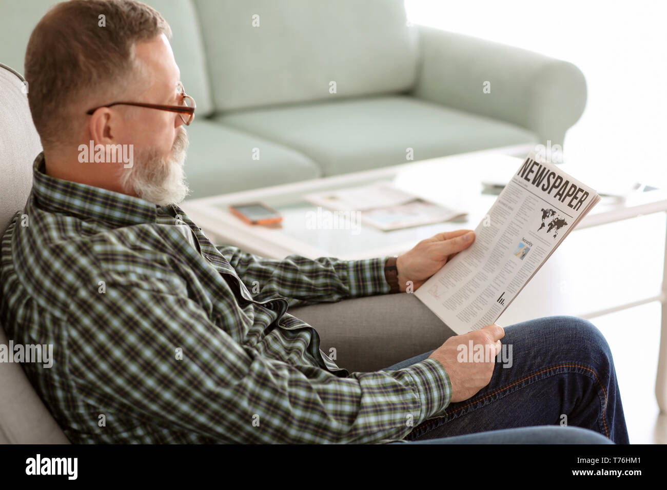 Senior uomo quotidiano di lettura a casa Foto Stock