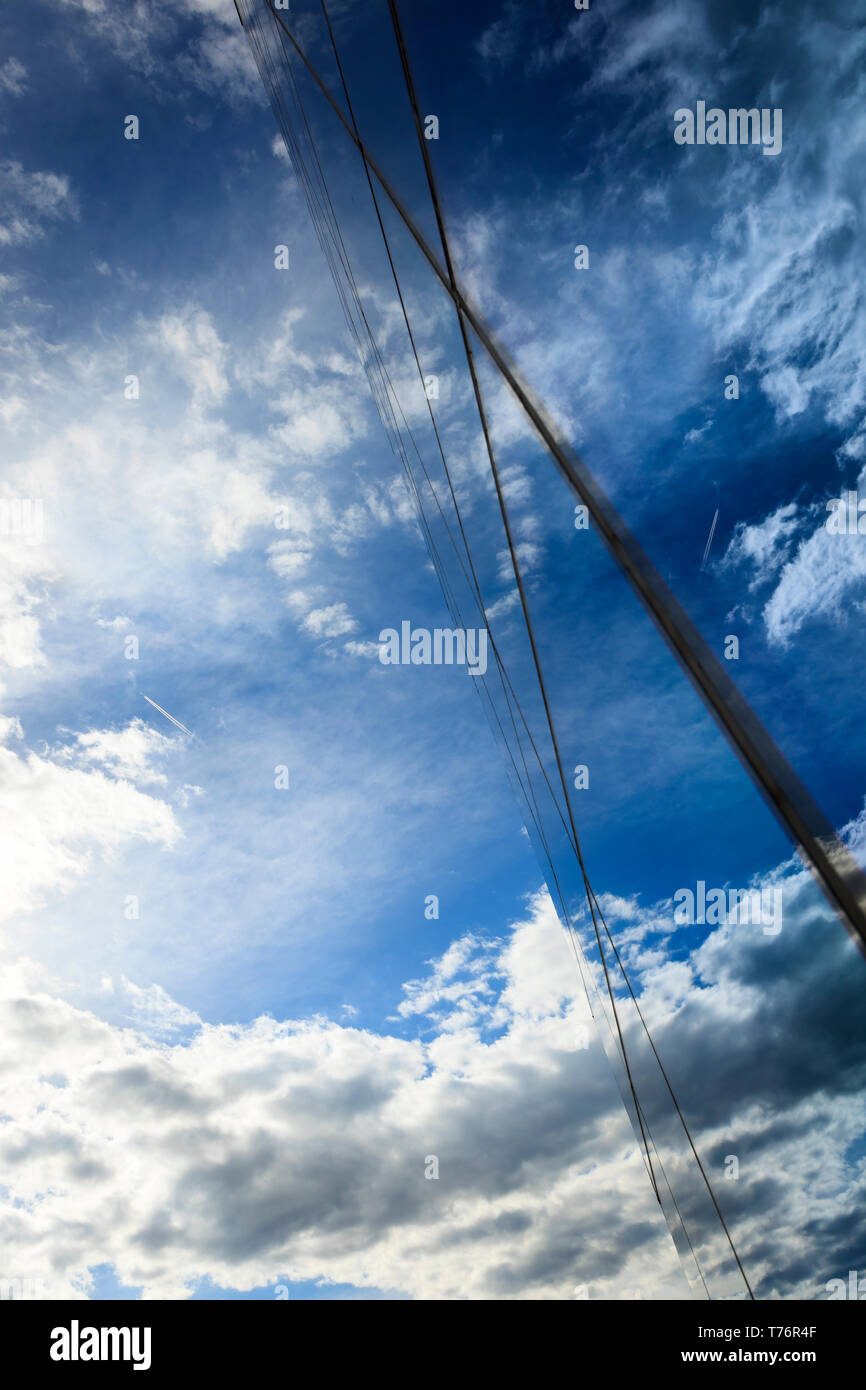 Nuvole e cielo blu riflessa sul vetro edificio per uffici di windows Foto Stock
