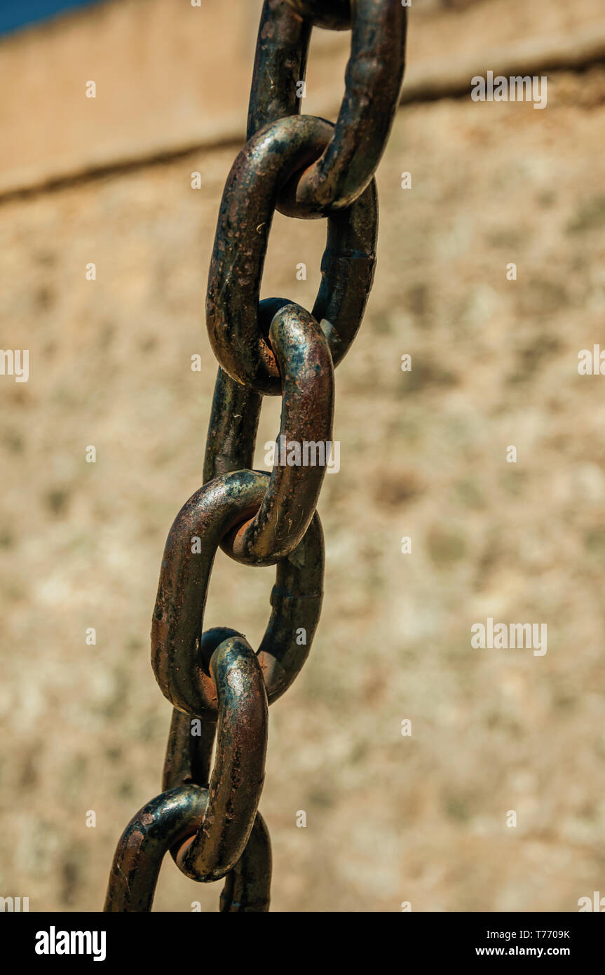 Close-up di ferro forte maglie di catena nella parte anteriore del muro di pietra, in una giornata di sole a Elvas. Una graziosa città sulla frontiera più orientale del Portogallo. Foto Stock