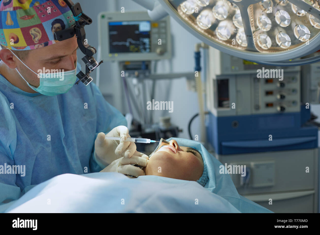 Molti medici che circonda il paziente sul tavolo di funzionamento durante il loro lavoro. I chirurghi del team a lavorare in sala operatoria. Foto Stock