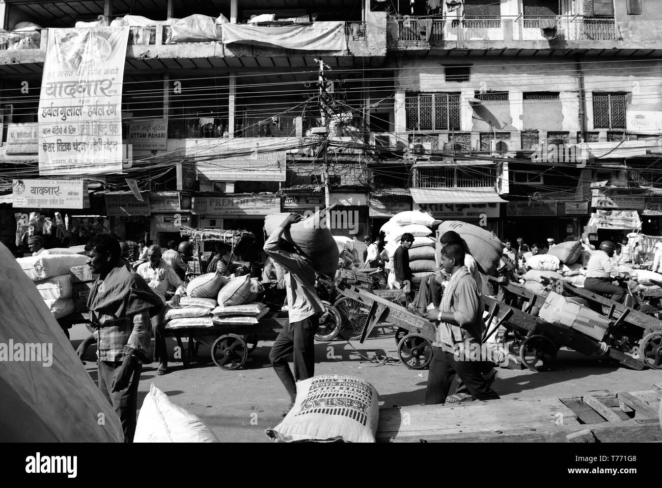 Il traffico della strada su Khari Baoli Road, Old Delhi, India, mercato delle spezie i facchini sono il trasporto di prodotti, frutta secca, noci e spezie. Foto Stock